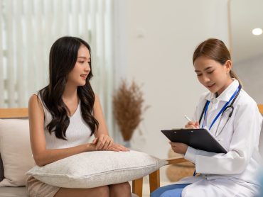 Asian doctor woman visited patient woman to diagnosis and check up health at home or private hospital. Female patient explain health problem and symptoms to doctor .Health care premium service at home