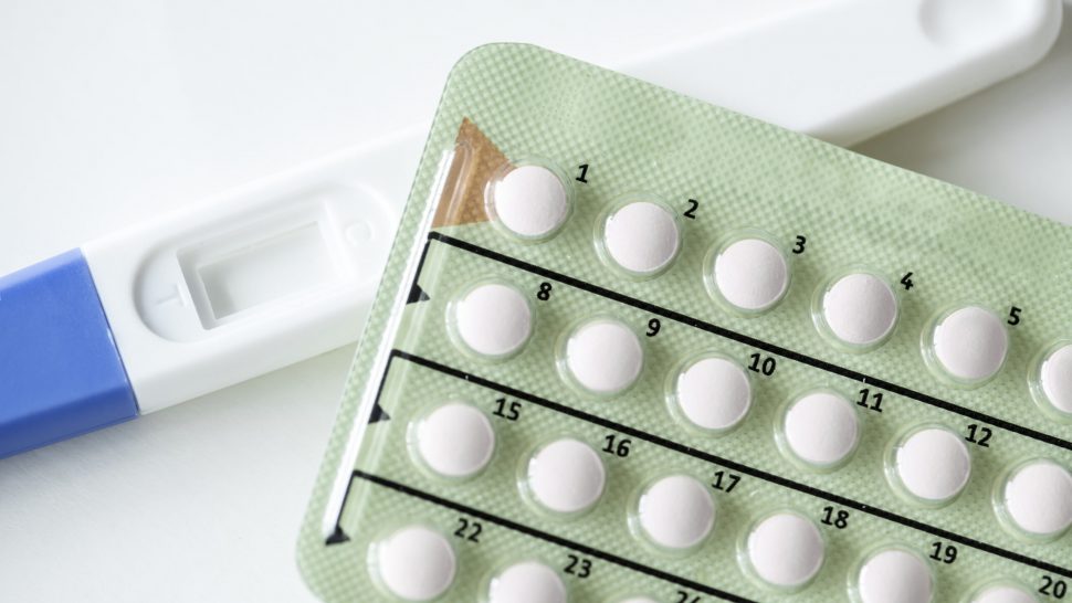 Closeup of pregnancy test and contraceptive pills birth control concept