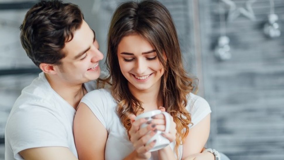 happy-woman-bed-with-her-man-she-is-holding-cup-tea-enjoying-time-together_496169-1171