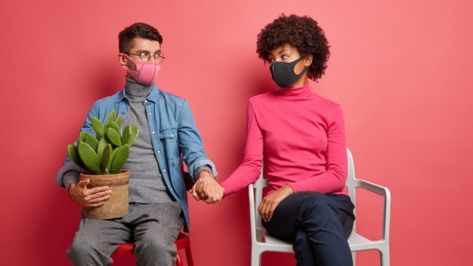 serious-husband-wife-infected-with-coronavirus-support-each-other-hold-hands-wear-protective-face-masks-sit-chairs-wear-casual-clothing-spend-time-home_273609-45426