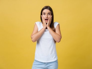 surprised-teenage-girl-show-shocking-expression-with-something-isolated-bright-yellow-background-copy-space_1258-80700