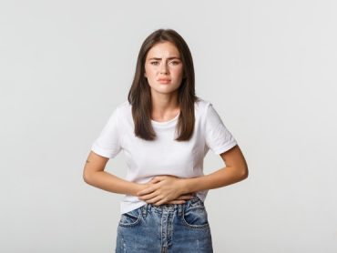 woman-having-stomach-ache-with-hands-belly-discomfort-from-menstrual-cramps-girl-feeling-nauseous_1258-19066